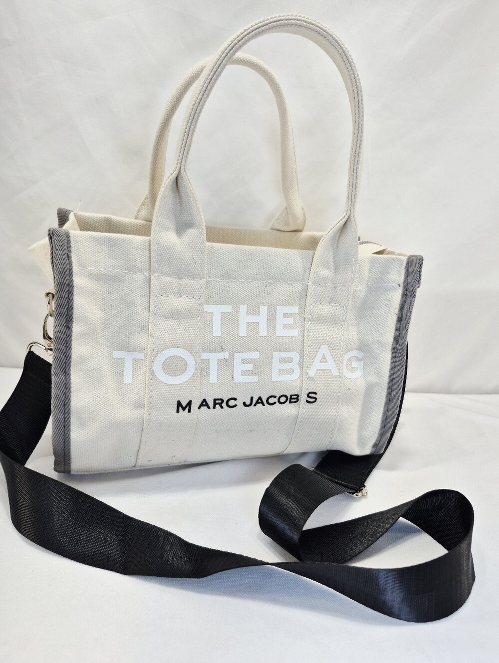 Marc Jacobs The Small Traveler Tote bag featuring beige canvas white Lettering